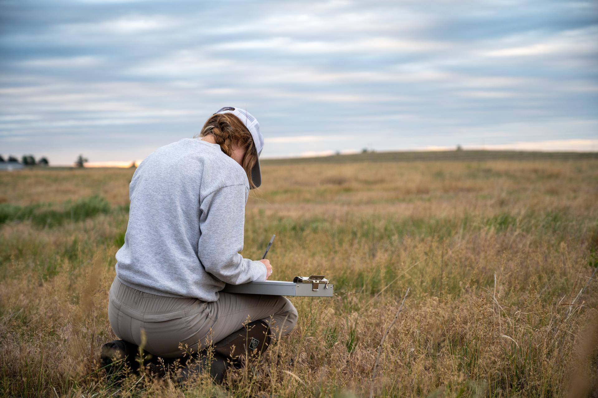 Student with clipboard in field